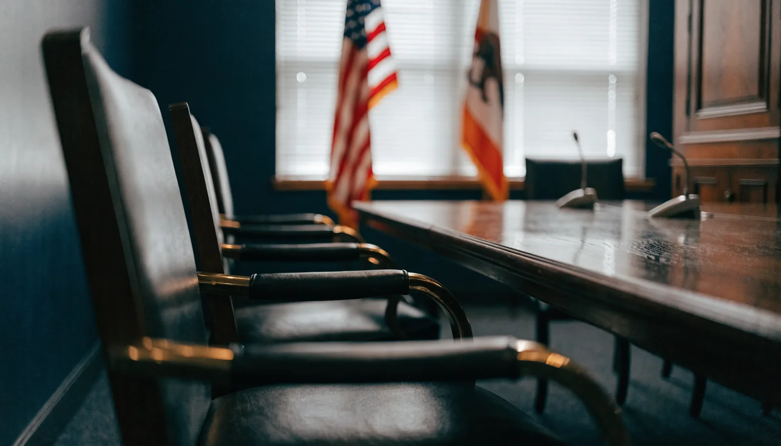 Formal administrative hearing room with a wooden table and flags, representing a California DMV DUI hearing